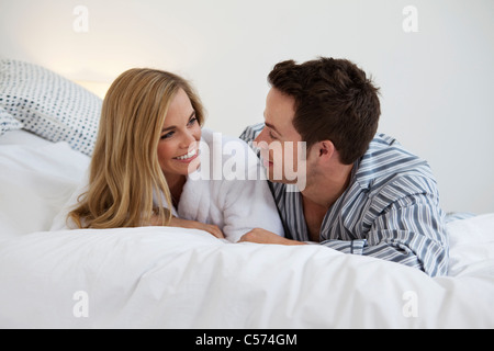 Paar im Bademantel auf Bett Stockfoto