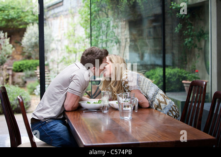 Paar küssen über Essen zu Hause Stockfoto