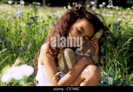 Kleines Mädchen auf einer Wiese kuscheln ihr Hase. Stockfoto