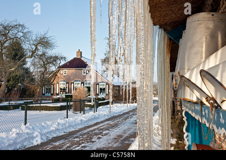 Niederlande, Staphorst, Winter, Eiszapfen auf Bauernhof Dach. Stockfoto