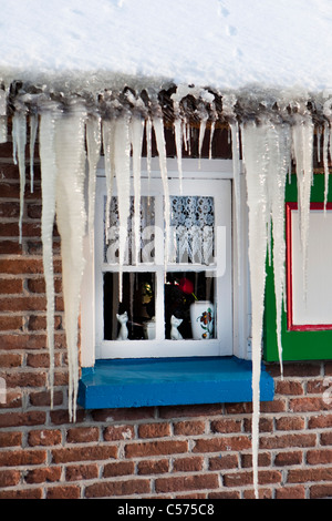 Niederlande, Staphorst, Winter, Eiszapfen auf Bauernhof Dach. Stockfoto