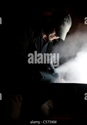 Steinmetz Schneiden von Stein mit sah in der Nacht Stockfoto