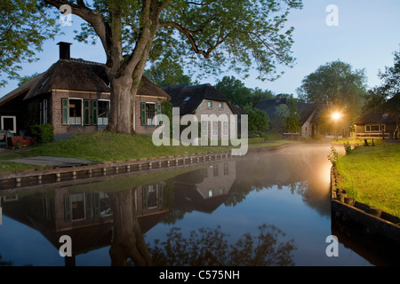 Die Niederlande, Dwarsgracht, in der Nähe von Giethoorn. Dorf mit fast nur Wasserstraßen. Häuser in der Morgendämmerung. Stockfoto