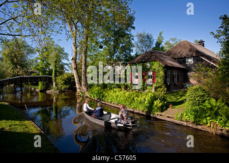 Die Niederlande, Giethoorn, Dorf mit fast nur Wasserstraßen. Touristen genießen Bootsfahrt. Stockfoto