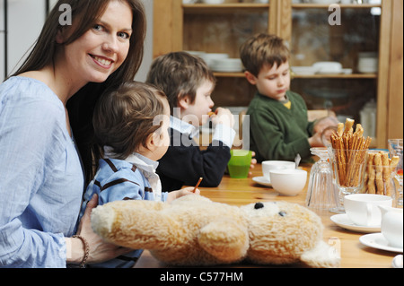 Mutter mit Söhnen am Tisch sitzen Stockfoto