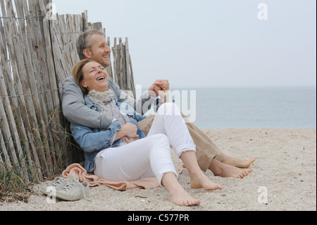 Älteres Ehepaar umarmt am Strand Stockfoto