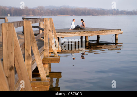 Paar am Steg mit Blick auf See sprechen Stockfoto