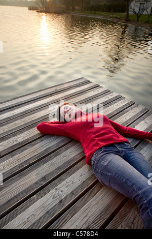 Frau Steg über See Handauflegen Stockfoto