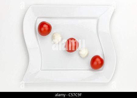 Mozzarellakugeln mit Kirschtomaten auf einem weißen Teller Stockfoto