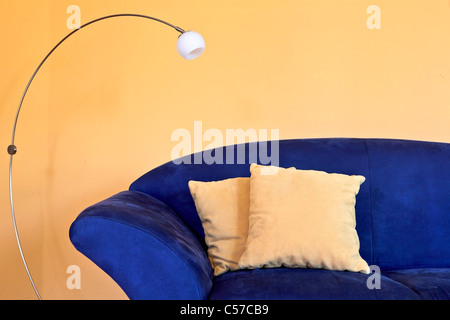 blauem Sofa mit Lese-Lampe und gelben Kissen und Wände Stockfoto