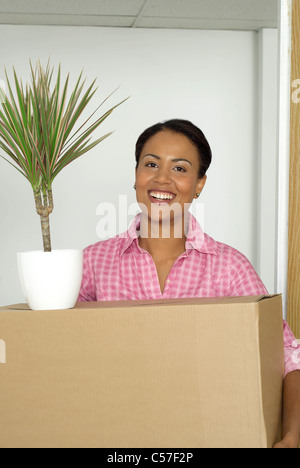 Frau, die Box und Topfpflanze Stockfoto