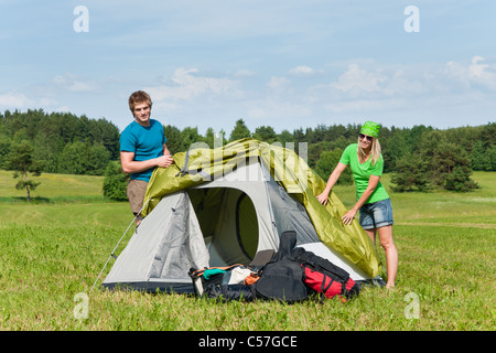 Junge Paar Aufbau Zelt im Sommer Wiesen Landschaft Stockfoto