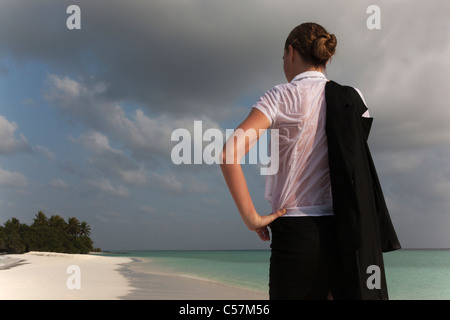 Frau trägt nasse Kleidung am Strand Stockfoto