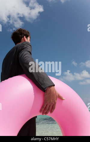 Geschäftsmann mit Schlauch am Strand Stockfoto