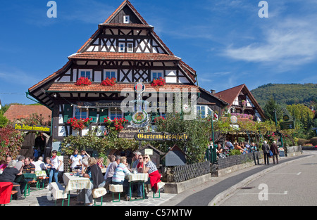 Menschen in einem Gartenrestaurant, Fachwerkhaus, Blumendekoration, Sasbachwalden, Nord Schwarzwald, Schwarzwald, Baden-Württemberg, Deutschland Stockfoto