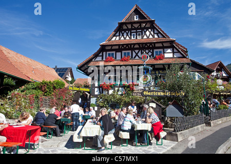 Menschen in einem Gartenrestaurant, Fachwerkhaus, Blumendekoration, Sasbachwalden, Nord Schwarzwald, Schwarzwald, Baden-Württemberg, Deutschland Stockfoto