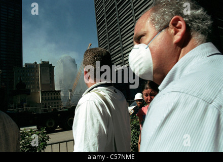 Menschen gehen den Broadway hinunter vorbei an der Website des World Trade Center Terroranschlags tragen Masken Stockfoto