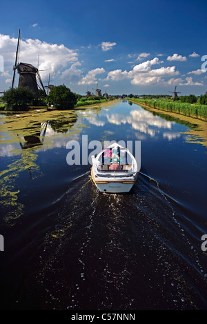 Den Niederlanden, Kinderdijk in der Nähe von Rotterdam. Windmühlen im Polder. UNESCO-Weltkulturerbe. Ehepaar und Hund im Boot. Stockfoto