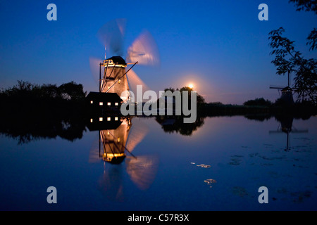 Den Niederlanden, Kinderdijk, beleuchtete Windmühle, UNESCO-Weltkulturerbe. Mondaufgang. Stockfoto