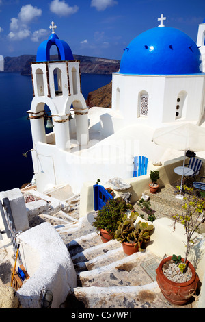 Oia, Santorini, griechische Insel, Griechenland, Stufen führen hinunter zu weiß gewaschen, Kirche und blauen gewölbte Glockenturm Stockfoto