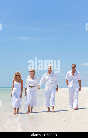 Vier Personen, zwei Senioren, Paare oder Familie Generationen Hand in Hand, Spaß zu haben und zu Fuß auf einem tropischen Strand Stockfoto