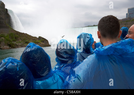 Touristen in blauem Kunststoff wasserdicht Ponchos Annäherung an den Horseshoe Falls auf Mädchen des Nebels Niagara Falls Ontario Kanada Stockfoto