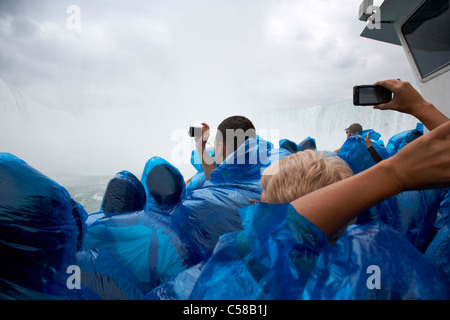 Touristen tragen blaue Kunststoff wasserdicht Ponchos fotografieren auf das Mädchen des Nebels, die Niagarafälle, Ontario Kanada Stockfoto