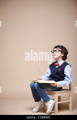 junge studieren auf Stuhl Stockfoto