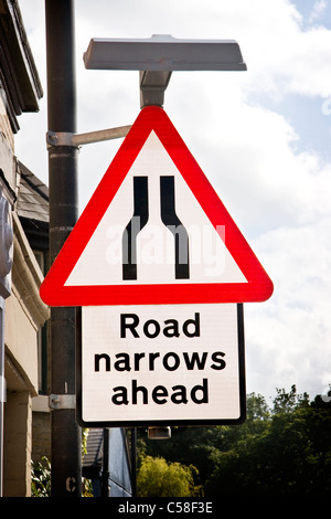 Straße verengt sich vor Verkehrszeichen, Suffolk, England Stockfoto