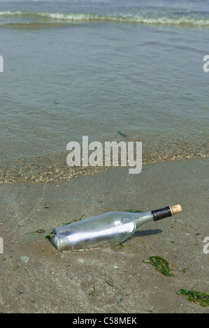 Eine Flaschenpost angespült am Sandstrand Stockfoto