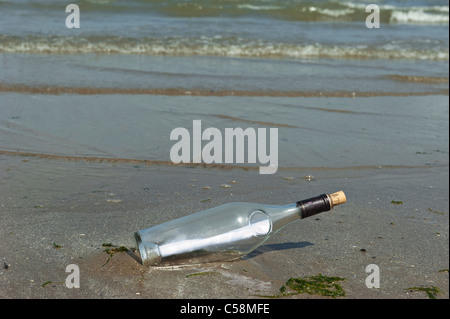 Eine Flaschenpost angespült am Sandstrand Stockfoto