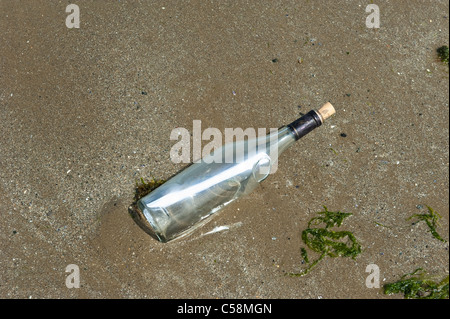 Eine Flaschenpost angespült am Sandstrand Stockfoto