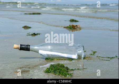 Eine Flaschenpost angespült am Sandstrand Stockfoto