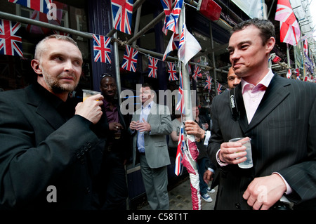 Männer in Compton Street Soho London mit Drink zusammen vor Pub auf königliche Hochzeit Stockfoto