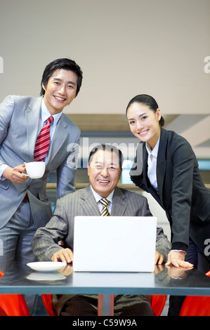 Porträt von Geschäftsleuten mit Laptop am Flughafen-lounge Stockfoto