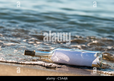 eine Flaschenpost mit Nachrichten in der Brandung Stockfoto