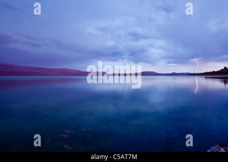 Blitzeinschlag auf See bei Sonnenuntergang. Stockfoto