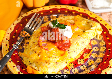 Südwestlichen Omelette mit Pilzen, Zwiebeln, Paprika mit Käse und kanadischer Speck, Salsa und Sauerrahm obenauf. Stockfoto