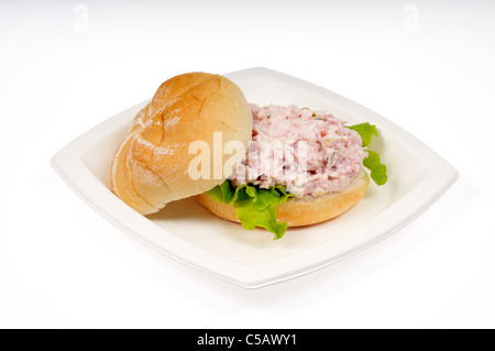 Schinken-Salat-Sandwich mit Salat in einer Rolle auf weißen Teller auf weißem Hintergrund ausschneiden. Stockfoto