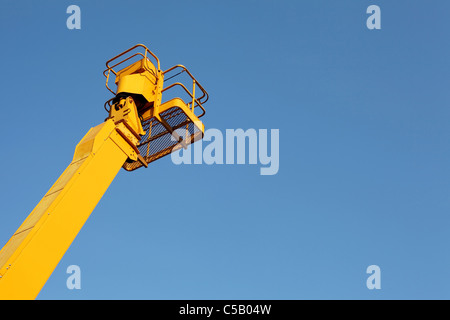 Gelbe Cherry-Picker vor blauem Himmel Stockfoto