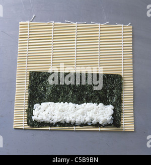 Kombu Schritt: Verlegung von Sushi-Reis auf das Nori-Blatt Stockfoto