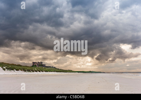 Blick am Strand entlang zum Bamburgh Castle in Northumberland Küste, Nord-Ost-England, Großbritannien Stockfoto