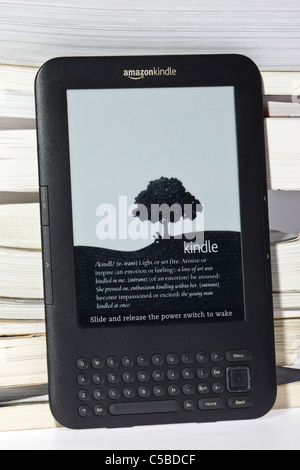 Amazon Kindle e-Reader neben einer unordentlichen Haufen traditionelle Bücher Stockfoto