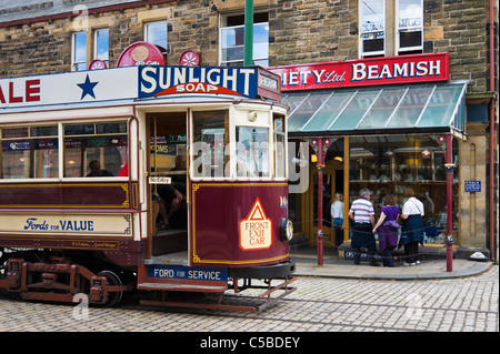 Alte Straßenbahn vor den Geschäften auf der High Street in The Town, Beamish Open Air Museum, County Durham, North East England, UK Stockfoto