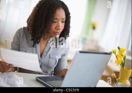 Gemischte Rassen Frau Rechnungen online bezahlen Stockfoto