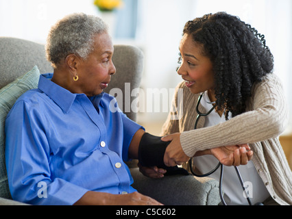 Krankenschwester Blutdruck nehmen Frau Stockfoto