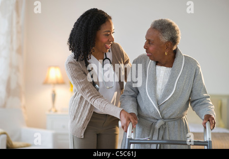 Krankenschwester hilft Frau mit Gehhilfe laufen Stockfoto