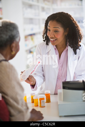 Apotheker Übergabe Medikamente an Frau Stockfoto