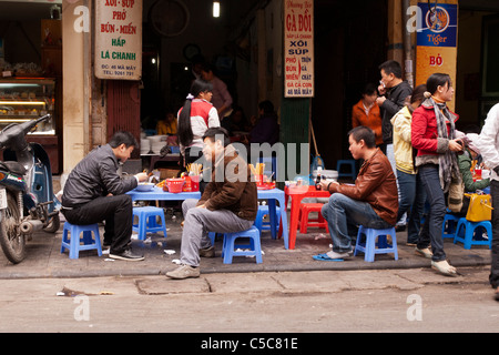 Kunden sitzen in einem Bürgersteig Restaurant in Ma kann St, Altstadt in Hanoi, Vietnam Stockfoto