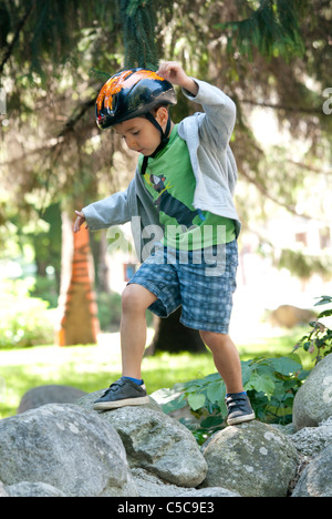 ein Junge auf einem, Felsen, mit Schutzhelm, Stockfoto